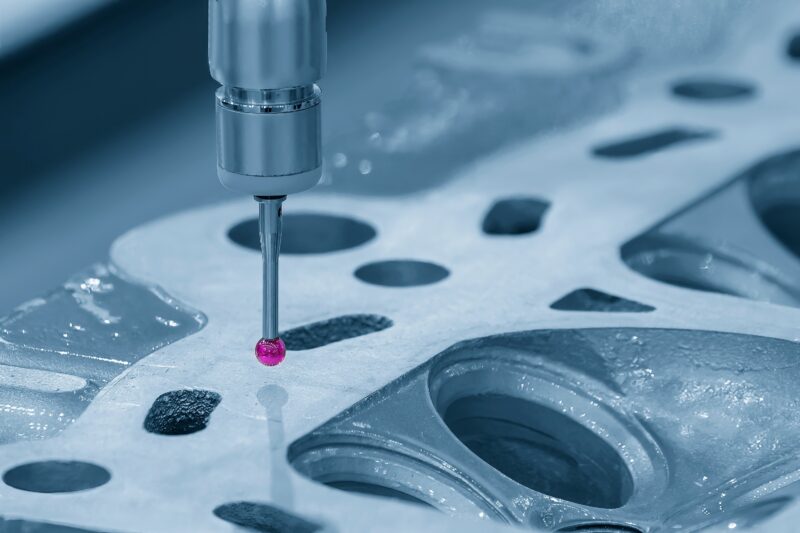 Coordinate measuring machine probe inspecting metallic component for precision auditing